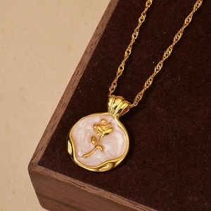 Elegant gold rose pendant necklace with mother of pearl inlay on wooden display