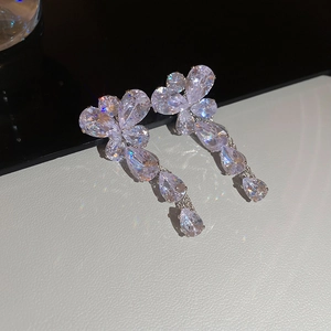 Close-up of sparkling zircon butterfly tassel earrings with silver finish on reflective base