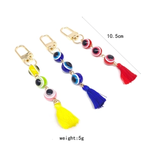 Detailed view of evil eye tassel keychains with length and weight measurement specs