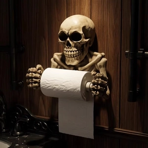 Gothic resin skull toilet paper holder mounted on a dark wood wall for Halloween decor