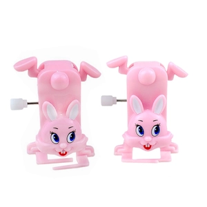 Close-up of pink wind-up walking bunny toys with mechanical clockwork knobs on white background