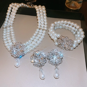 Detailed view of rhinestone clover jewelry set with teardrop pearls in a premium gift box