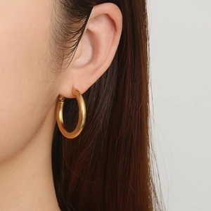 Minimalist thick hollow round 18K gold-plated hoop earrings on a fashion model