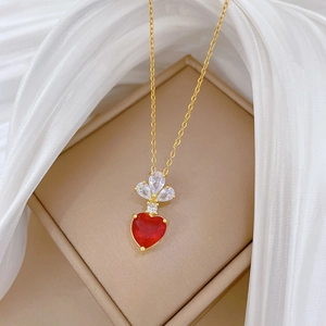 Detail of red heart gemstone necklace with white zircon accents on white silk