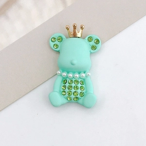 Detail of mint green bear charm with golden crown, pearls and green rhinestones