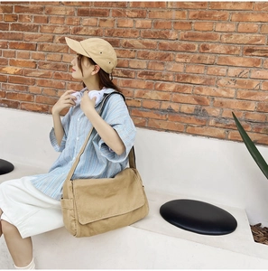 Khaki washed canvas messenger bag styled with a striped shirt for a casual urban look