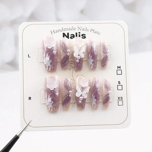 Detail of handmade press-on nails with purple gradient, 3D flowers, and pearl accents