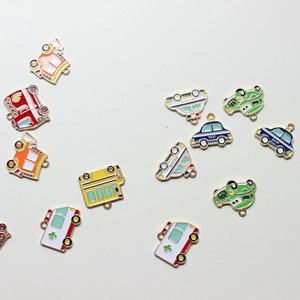 Detailed macro shot of assorted colorful enamel cartoon vehicle charms for DIY jewelry