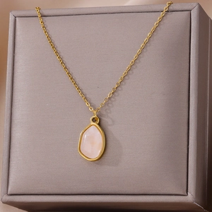 Detail of green irregular stone pendant on gold-plated titanium O-chain in jewelry box
