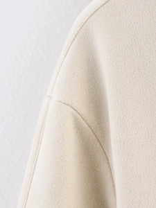 Macro shot of apricot velvet texture knit fabric and stitching on the jacket shoulder