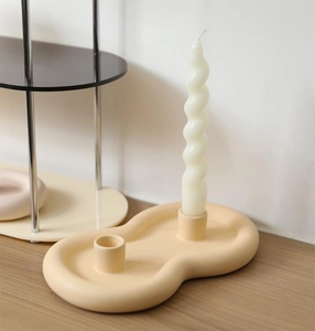 Detailed macro view of cream matte ceramic double-hole candle holder on a wooden table