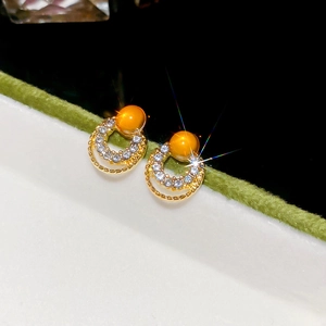 Macro detail of gold geometric hoop earrings with opal and sparkling crystal inlay