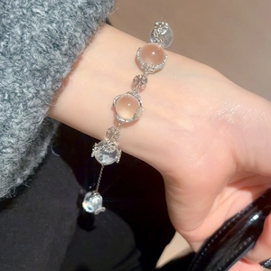 Detail of silver snowflake charm bracelet with pink crystal beads on model's wrist