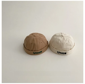 Dettaglio dei berretti docker Unice ricamati per bambini in cotone kaki e crema