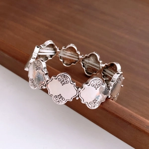 Makro-Detail eines Vintage-Armbands in Silber mit gravierten Scroll-Mustern
