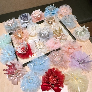 Close-up of assorted princess hair clips with lace, satin bows, and glittery crowns