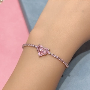 Close-up of heart-shaped pink zircon bracelet with pavé pink stones on the hand