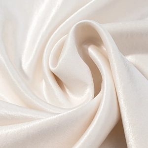Close-up of elegant white satin fabric showing soft silk-like texture and glossy waves