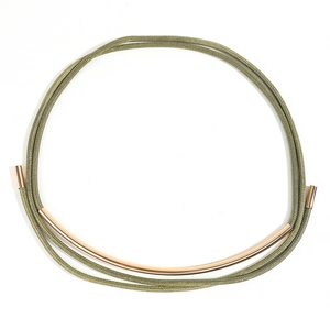 Detail of olive green braided wax cord belt with long golden metal arc ornament