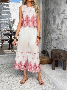 Detailed view of white cotton-linen two-piece set featuring red embroidery and scalloped edges