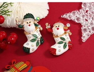 Detailed view of two Christmas Santa brooches with enamel finish and sparkling rhinestones