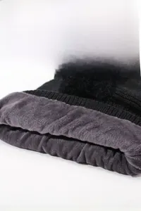 Close-up of winter knit hat featuring thick grey faux fur lining and soft black yarn