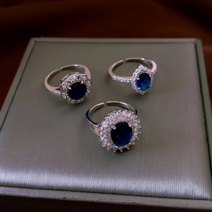Dettaglio macro di tre anelli regolabili in argento con pietre di zircone blu intenso