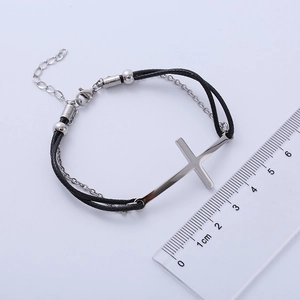 Detail view of black braided bracelet with silver cross measuring approximately 4.5cm long