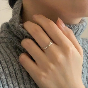 Detail shot of a minimalist 925 silver bamboo-style ring on a finger with grey sweater