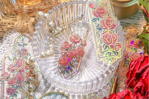 Close-up of vintage laser-foiled rose bookmarks with golden embossed details on a glass tray