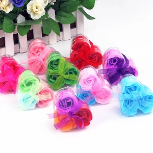 Three heart-shaped soap flowers in a clear plastic gift box with decorative ribbon