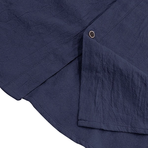 Dettaglio del tessuto in lino blu scuro con un bottone in legno scuro di qualità
