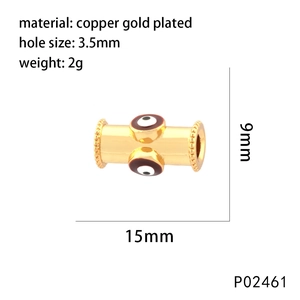 Détail d'une perle barillet en cuivre plaqué or avec œil émaillé pour bijoux DIY