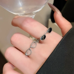 Close-up of creative Y2K sunglasses style rings with black and clear lens detail