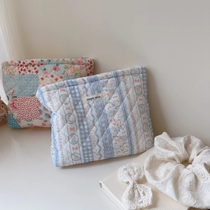 Detail of floral and plaid quilted cotton makeup bags with simple wish fabric label