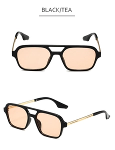 Close-up of retro double-bridge pilot sunglasses with black frame and tea-colored lenses