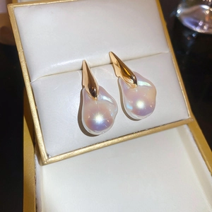 Dettaglio macro di orecchini con perle barocche irregolari e finiture in oro 18 carati nel cofanetto