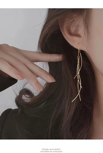 Detail of 18K gold S925 sterling silver long tassel drop earrings worn by a model