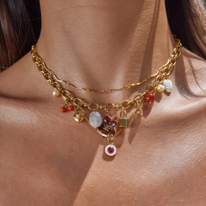 Gold stainless steel multi-pendant necklace with pearls and floral charms on model