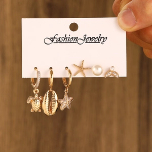 Gold 6-piece sea-inspired earring set with turtle, shell, and star motifs on card