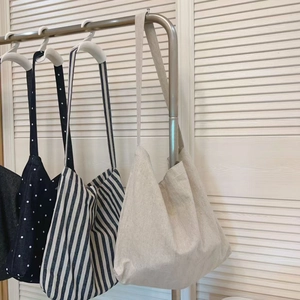 Detailed view of large canvas tote bags in polka dot, striped, and linen patterns