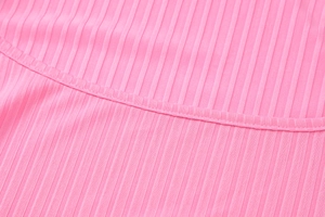 Gros plan sur un tissu en maille côtelée rose vif avec coutures détaillées d'une robe
