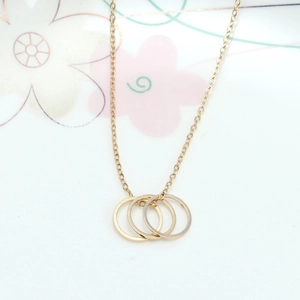 Detail shot of golden interlocking karma rings necklace on delicate link chain