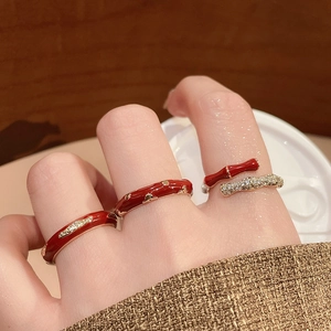 Detail of red enamel rings with 14k gold plating and zircon inlay shown on hand