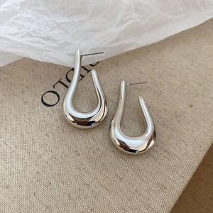 Detailed view of polished silver U-shaped droplet earrings with smooth metallic finish