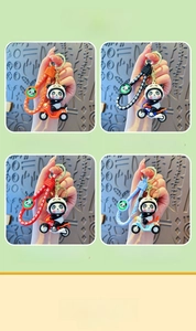 Dettaglio di portachiavi panda su moto nei colori arancione, nero, rosso e blu per borse