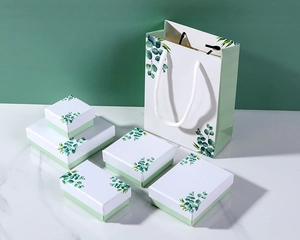 Detailed set of eucalyptus themed jewelry boxes and matching gift bag on marble