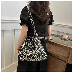 Detail of hobo shoulder bag with black and white leopard print fabric texture