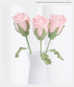 Detailed view of three handmade pink crochet roses in a white ceramic vase decoration