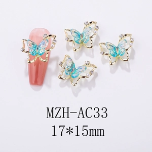 Macro view of blue butterfly nail charms with rhinestones and pearls on white background